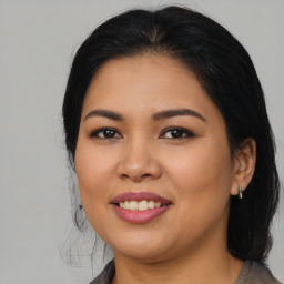 Joyful latino young-adult female with medium  brown hair and brown eyes