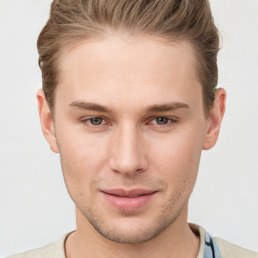 Joyful white young-adult male with short  brown hair and grey eyes