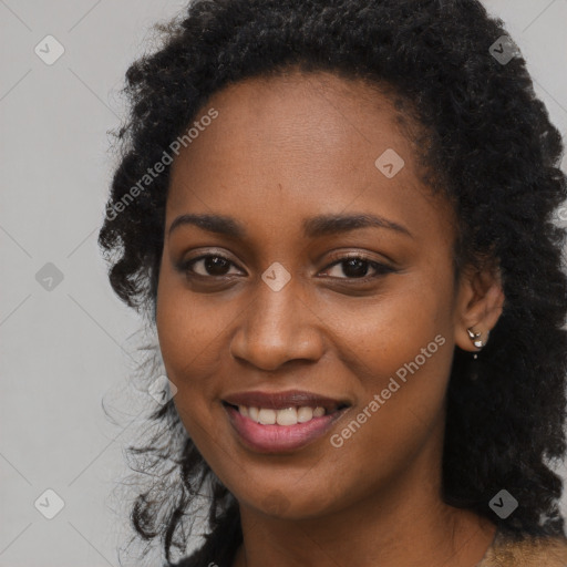 Joyful black young-adult female with long  black hair and brown eyes