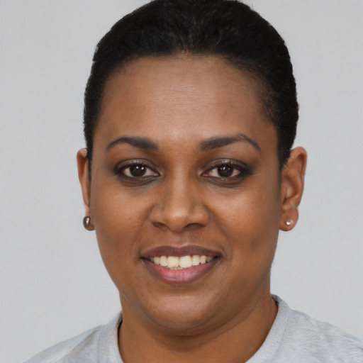 Joyful black young-adult female with short  black hair and brown eyes
