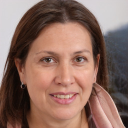 Joyful white adult female with long  brown hair and brown eyes