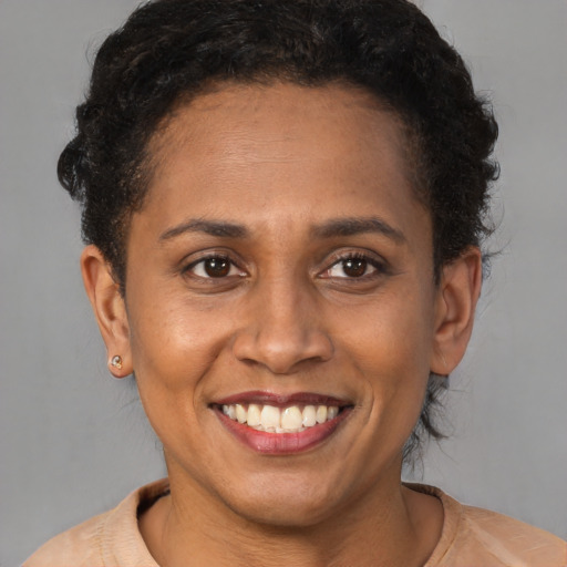 Joyful latino young-adult female with short  brown hair and brown eyes