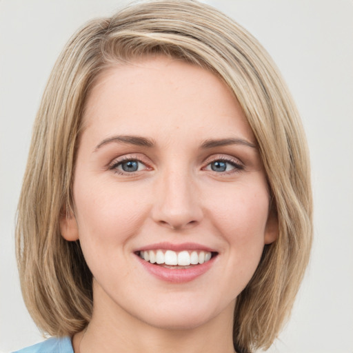 Joyful white young-adult female with medium  brown hair and green eyes