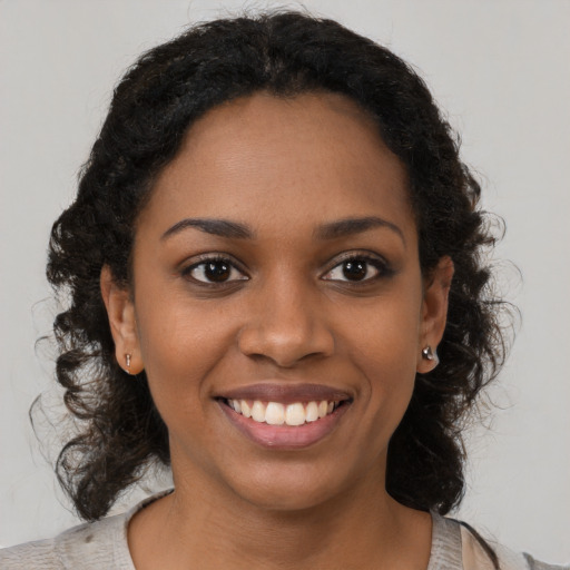 Joyful black young-adult female with medium  brown hair and brown eyes