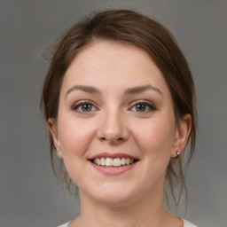 Joyful white young-adult female with medium  brown hair and grey eyes