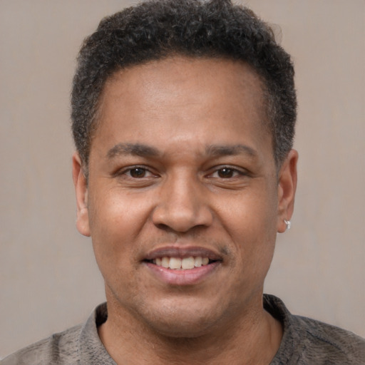 Joyful latino adult male with short  brown hair and brown eyes