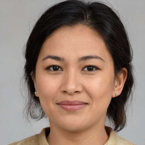 Joyful latino young-adult female with medium  brown hair and brown eyes