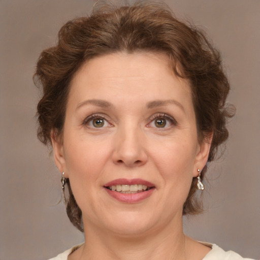 Joyful white adult female with medium  brown hair and green eyes