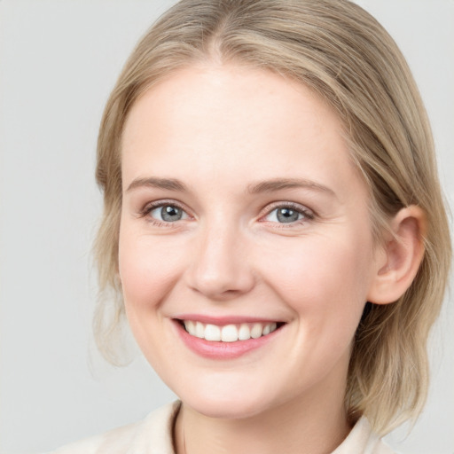 Joyful white young-adult female with medium  brown hair and blue eyes