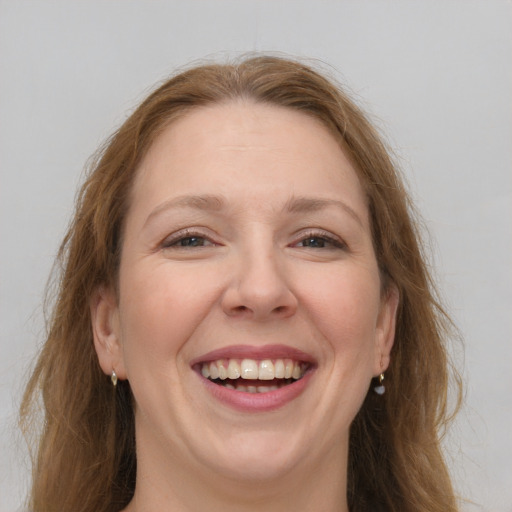 Joyful white adult female with long  brown hair and grey eyes