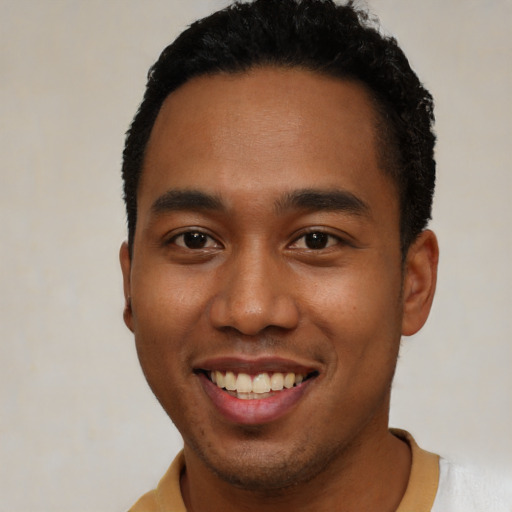 Joyful black young-adult male with short  black hair and brown eyes