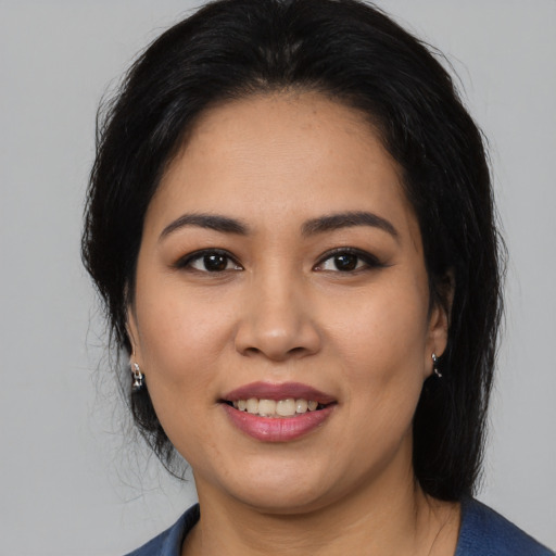 Joyful latino young-adult female with medium  black hair and brown eyes