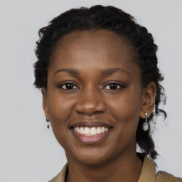 Joyful black young-adult female with long  brown hair and brown eyes