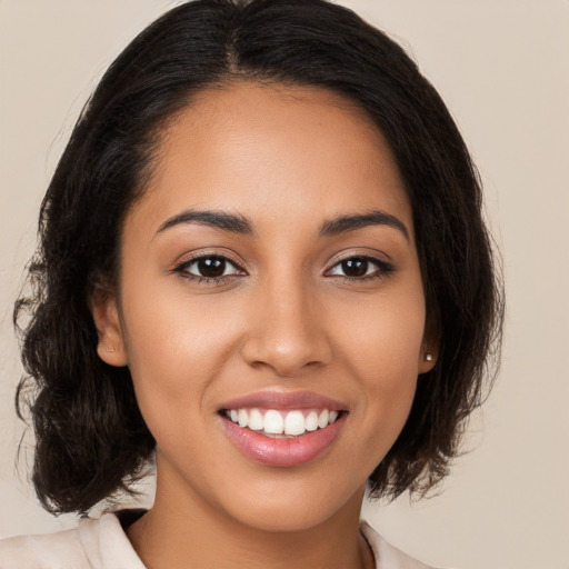 Joyful latino young-adult female with long  brown hair and brown eyes