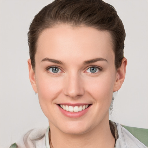 Joyful white young-adult female with short  brown hair and grey eyes