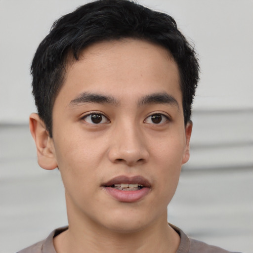 Joyful asian young-adult male with short  black hair and brown eyes