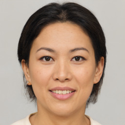 Joyful white adult female with medium  brown hair and brown eyes