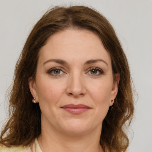 Joyful white young-adult female with medium  brown hair and green eyes