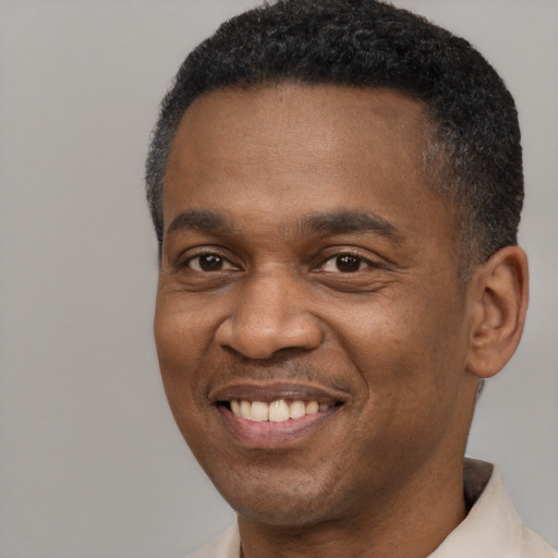 Joyful black adult male with short  brown hair and brown eyes