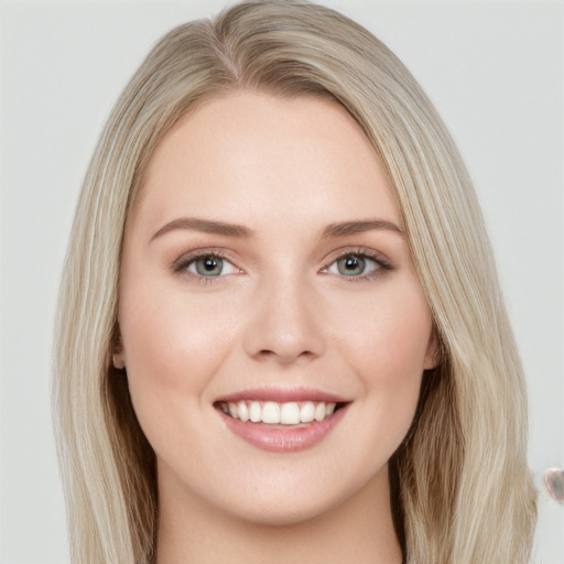 Joyful white young-adult female with long  brown hair and blue eyes