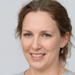 Joyful white adult female with medium  brown hair and grey eyes