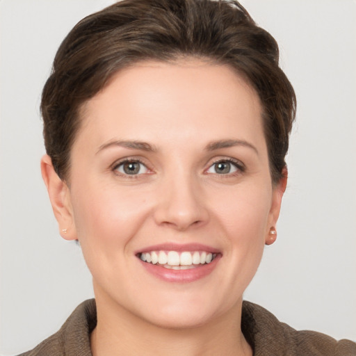 Joyful white young-adult female with short  brown hair and grey eyes