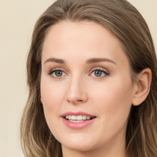 Joyful white young-adult female with long  brown hair and green eyes