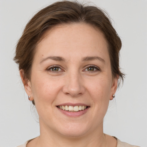 Joyful white young-adult female with medium  brown hair and grey eyes