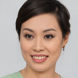 Joyful asian young-adult female with medium  brown hair and brown eyes