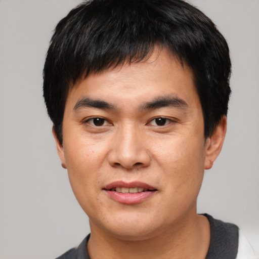 Joyful asian young-adult male with short  black hair and brown eyes