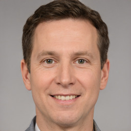 Joyful white adult male with short  brown hair and grey eyes