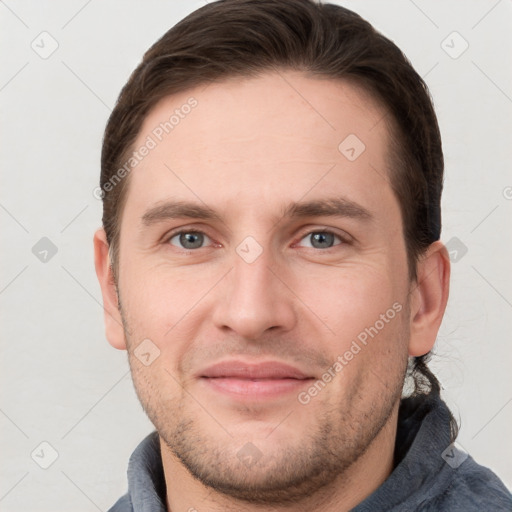 Joyful white young-adult male with short  brown hair and grey eyes