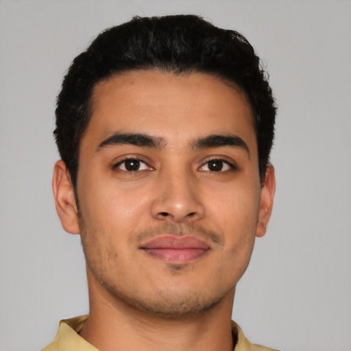 Joyful latino young-adult male with short  brown hair and brown eyes