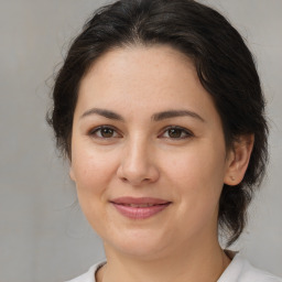 Joyful white young-adult female with medium  brown hair and brown eyes