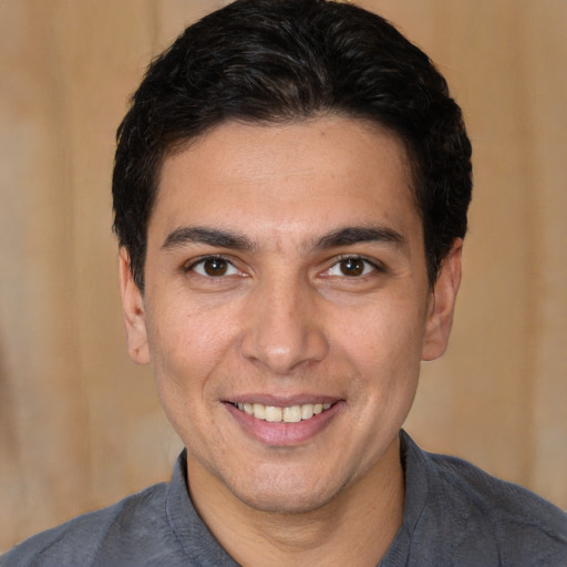 Joyful white young-adult male with short  black hair and brown eyes