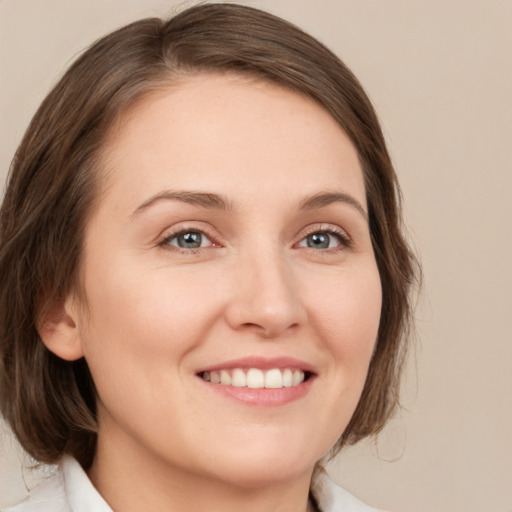 Joyful white young-adult female with medium  brown hair and green eyes