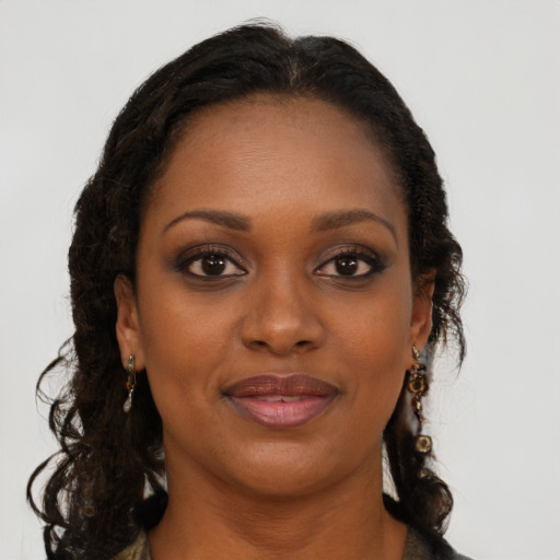 Joyful black young-adult female with long  brown hair and brown eyes