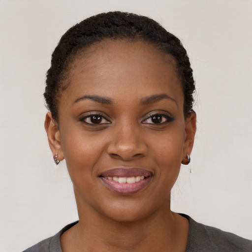 Joyful black young-adult female with short  black hair and brown eyes
