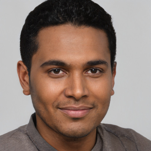 Joyful black young-adult male with short  black hair and brown eyes
