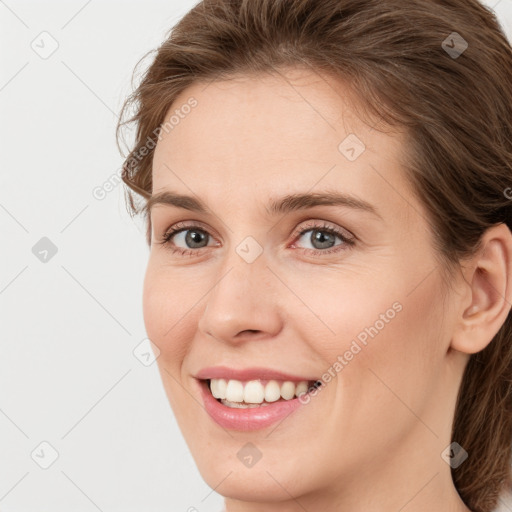 Joyful white young-adult female with long  brown hair and green eyes