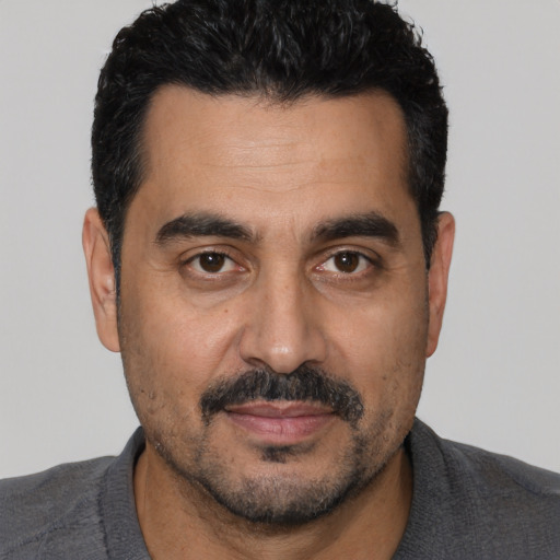 Joyful white adult male with short  black hair and brown eyes