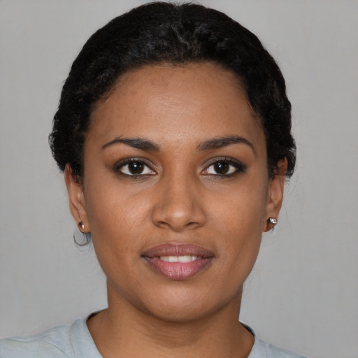 Joyful black young-adult female with short  black hair and brown eyes