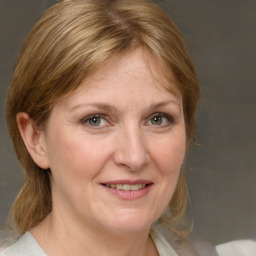 Joyful white adult female with medium  brown hair and grey eyes