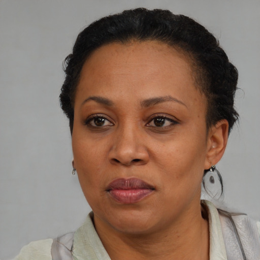 Joyful black adult female with short  black hair and brown eyes