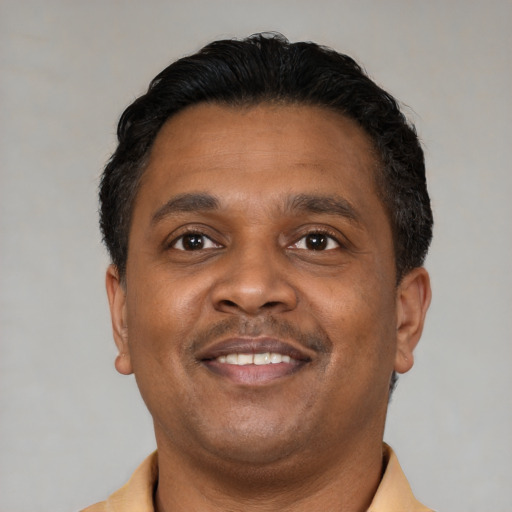 Joyful latino adult male with short  brown hair and brown eyes