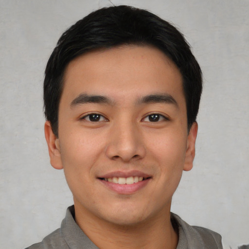 Joyful asian young-adult male with short  black hair and brown eyes