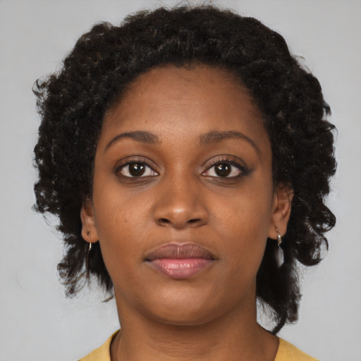 Joyful black young-adult female with medium  brown hair and brown eyes