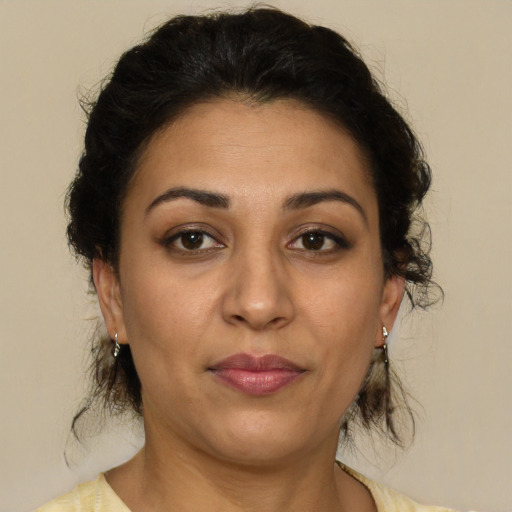 Joyful latino adult female with medium  brown hair and brown eyes