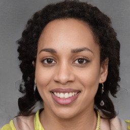 Joyful black young-adult female with long  brown hair and brown eyes