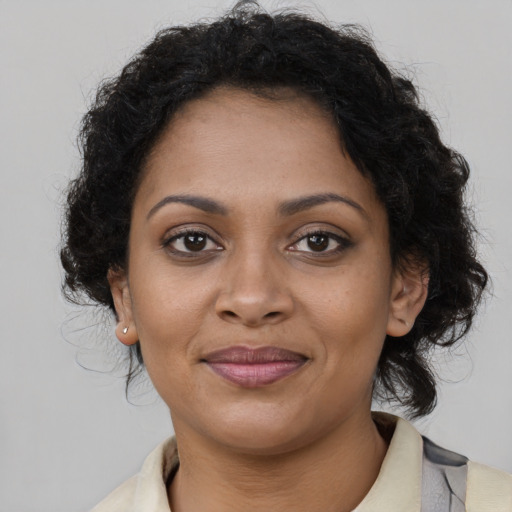 Joyful black young-adult female with long  brown hair and brown eyes